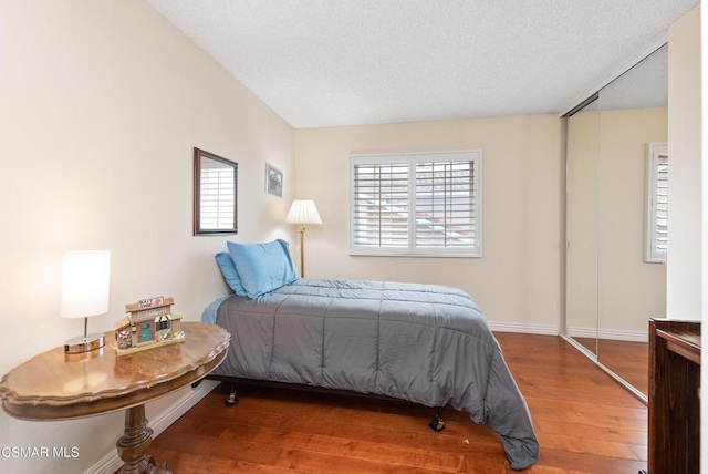 bedroom with wood-type flooring and a textured ceiling