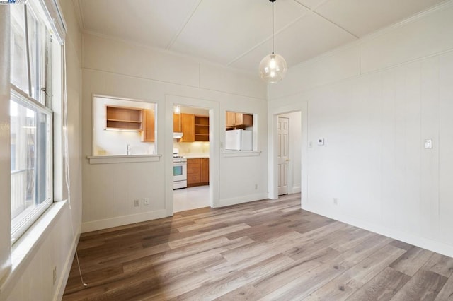 unfurnished room featuring ornamental molding and light hardwood / wood-style flooring