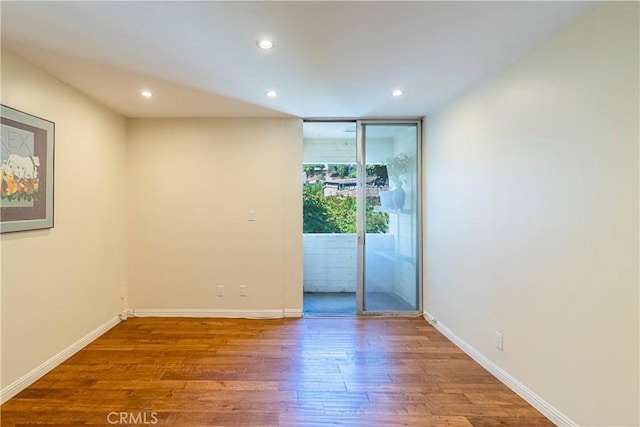 spare room featuring wood-type flooring and floor to ceiling windows