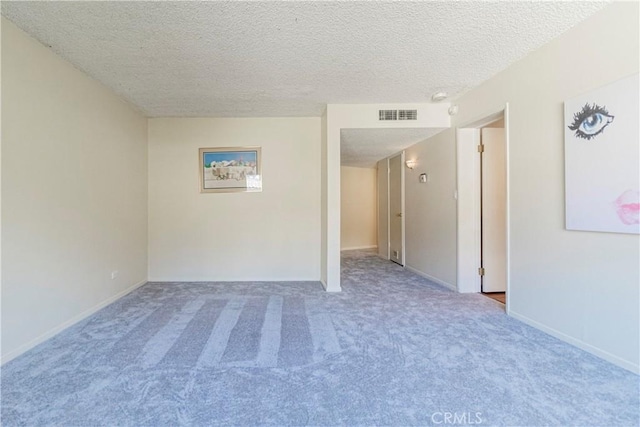 unfurnished room with carpet flooring and a textured ceiling