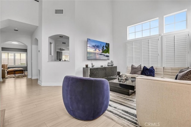 living room with a high ceiling and light hardwood / wood-style flooring