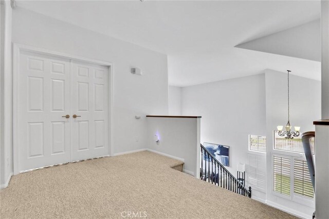 hallway with a chandelier and carpet