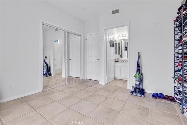 interior space with light tile patterned floors and ensuite bath