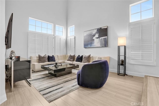 living room featuring a high ceiling and light hardwood / wood-style floors