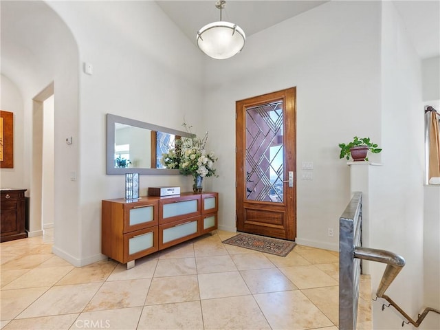 entrance foyer with light tile patterned floors and a towering ceiling