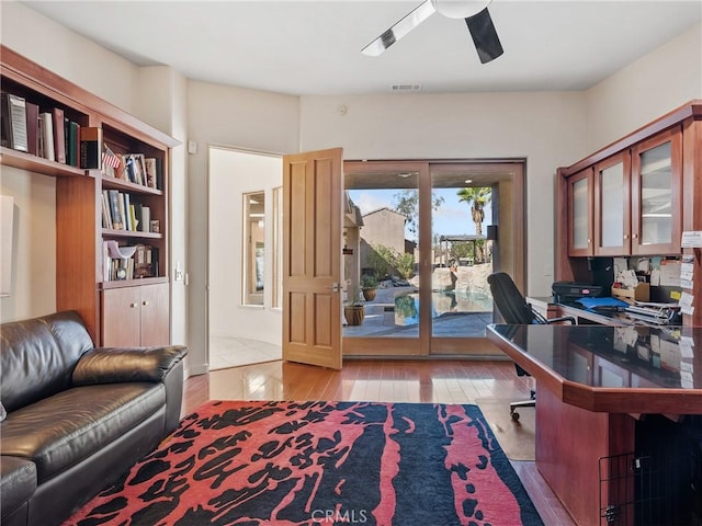 home office featuring light hardwood / wood-style floors and ceiling fan