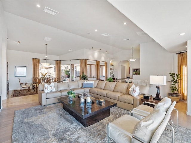 living room with vaulted ceiling and light wood-type flooring