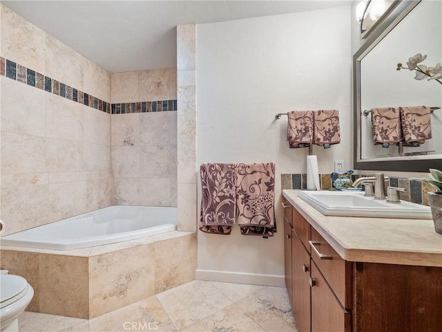 bathroom featuring tile patterned flooring, vanity, a relaxing tiled tub, and toilet