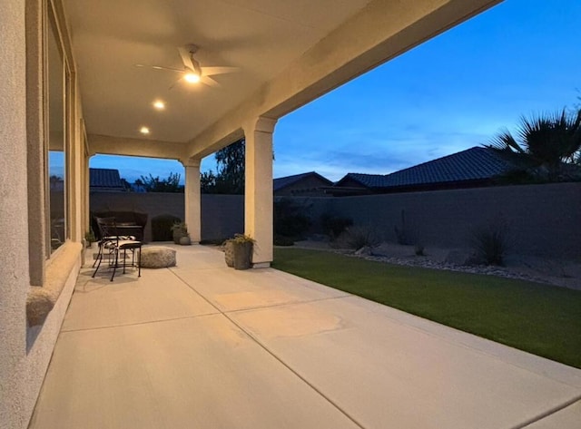 patio terrace at dusk featuring ceiling fan