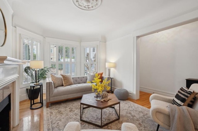 living room featuring light wood-type flooring and a high end fireplace