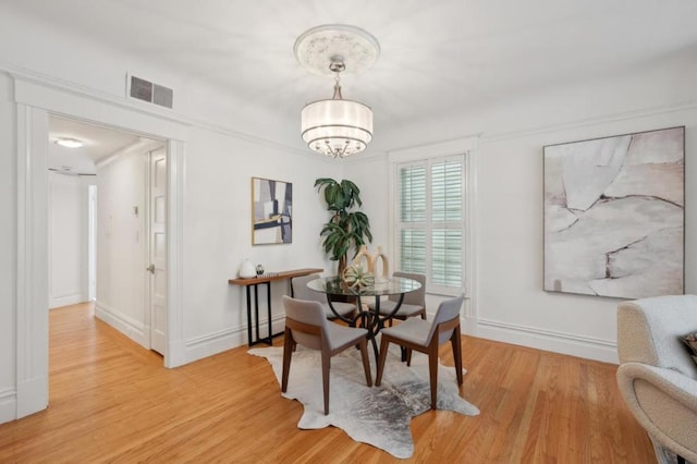 dining area with an inviting chandelier and light wood-type flooring