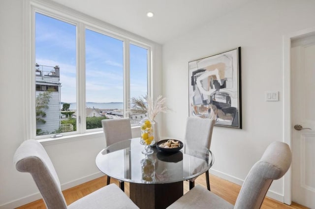 dining room with a water view and light wood-type flooring