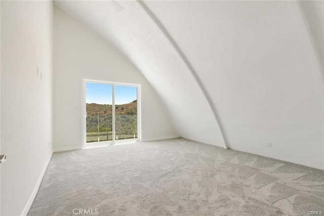 additional living space with vaulted ceiling and light carpet