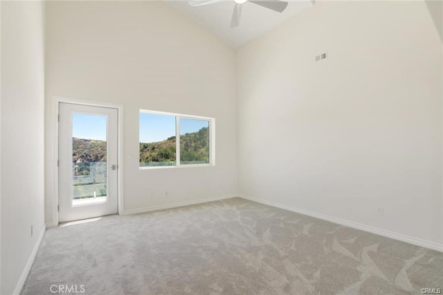 unfurnished room with ceiling fan, light colored carpet, and high vaulted ceiling