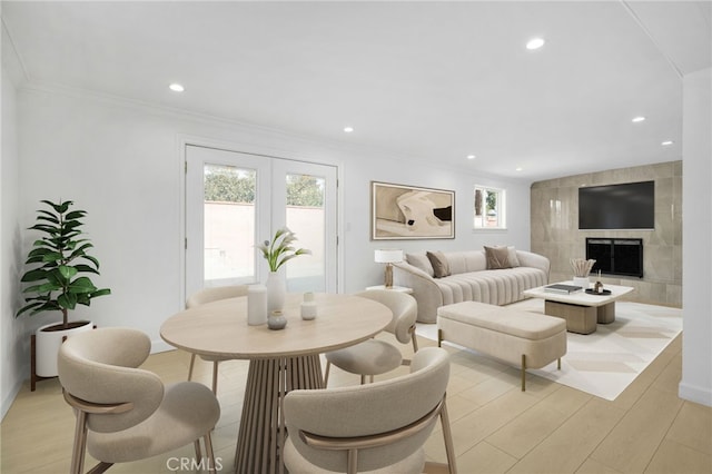 living room with recessed lighting, light wood-style flooring, a tile fireplace, and ornamental molding