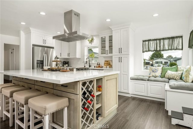 kitchen featuring a kitchen island, dark hardwood / wood-style floors, island range hood, white cabinets, and stainless steel refrigerator with ice dispenser