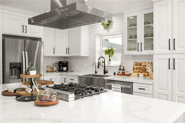 kitchen with sink, white cabinetry, tasteful backsplash, island range hood, and appliances with stainless steel finishes