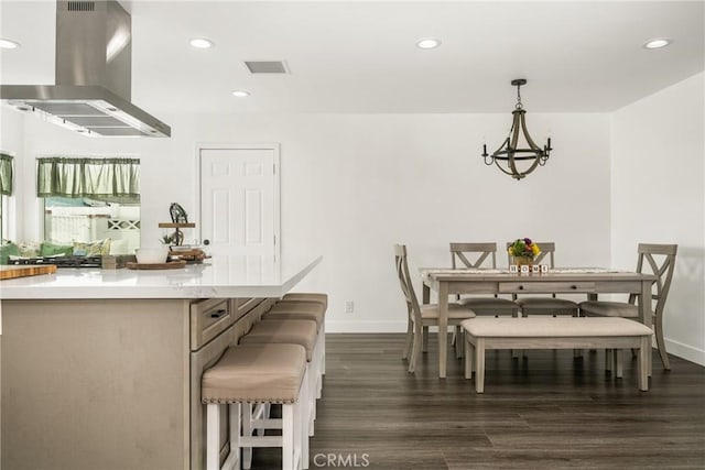 dining room with dark hardwood / wood-style floors and a notable chandelier