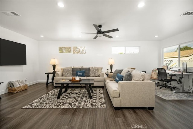 living room featuring dark wood-type flooring and ceiling fan