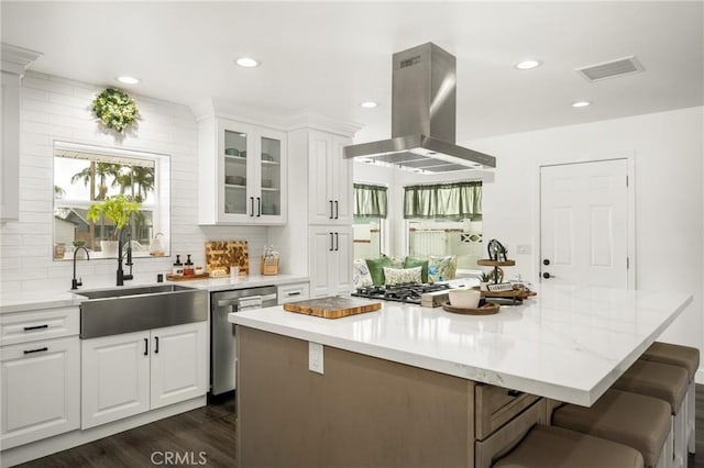 kitchen featuring sink, white cabinetry, island range hood, a kitchen island, and stainless steel appliances