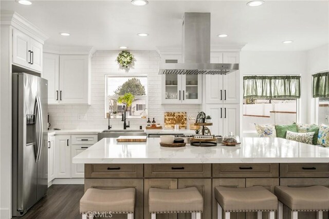 kitchen with stainless steel fridge and white cabinets