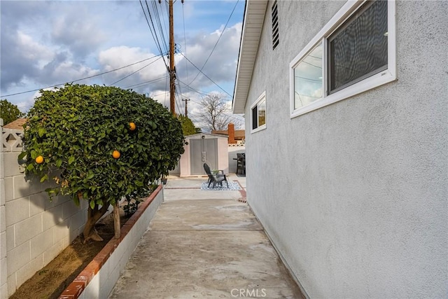 view of property exterior featuring a storage shed and a patio area