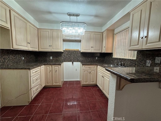 kitchen featuring a breakfast bar area, backsplash, dark tile patterned flooring, hanging light fixtures, and an inviting chandelier