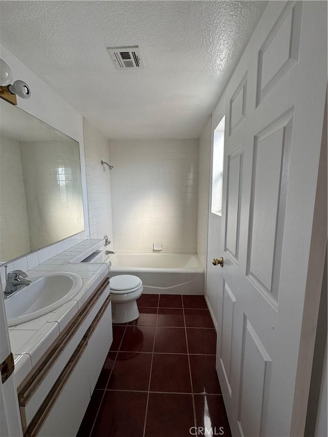 full bathroom featuring tiled shower / bath, tile patterned floors, vanity, and a textured ceiling