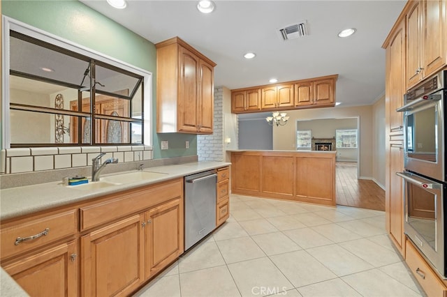 kitchen with light tile patterned flooring, sink, ornamental molding, stainless steel appliances, and decorative backsplash