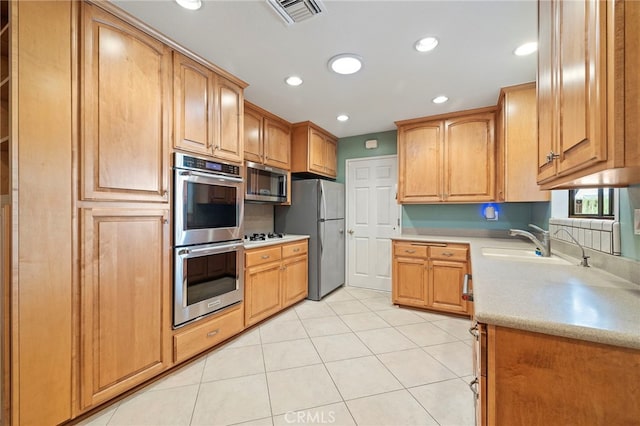 kitchen with sink, light tile patterned floors, and stainless steel appliances