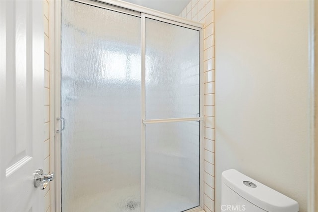 bathroom featuring toilet and walk in shower