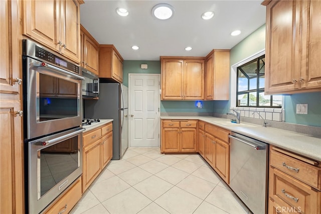 kitchen featuring light tile patterned floors, stainless steel appliances, and sink