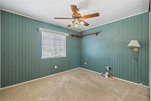 carpeted empty room featuring crown molding and ceiling fan