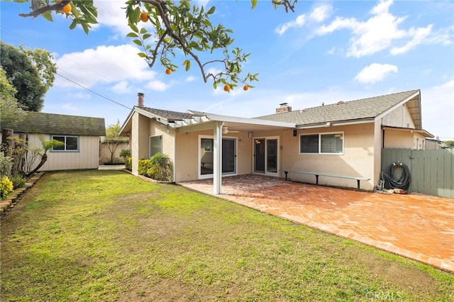 rear view of house with a storage unit and a lawn