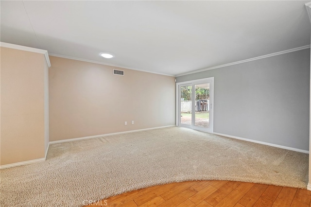 spare room with ornamental molding and hardwood / wood-style floors