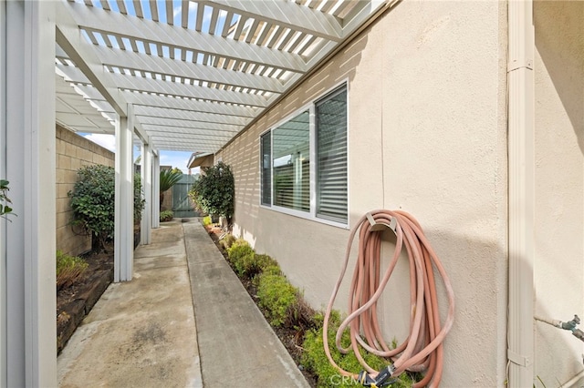 view of property exterior with a patio and a pergola