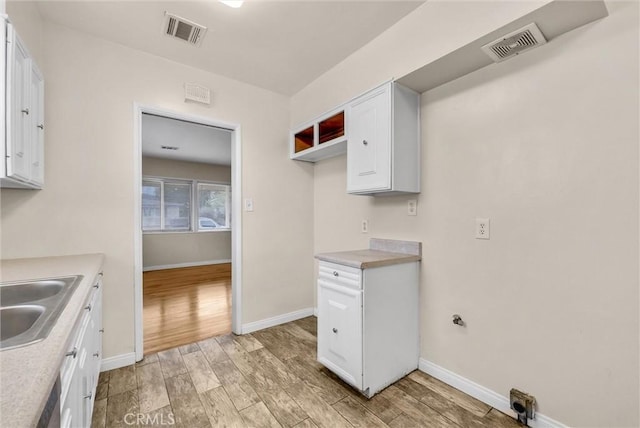 kitchen featuring light hardwood / wood-style floors, sink, and white cabinets