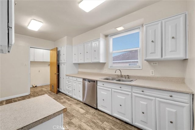 kitchen with white cabinetry, sink, stainless steel dishwasher, and light wood-type flooring