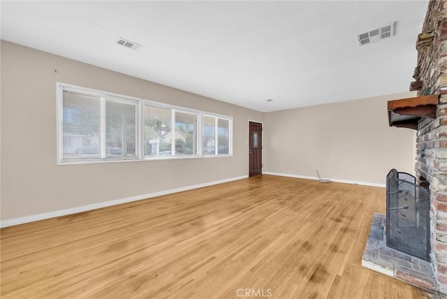 unfurnished living room featuring light hardwood / wood-style floors and a wood stove