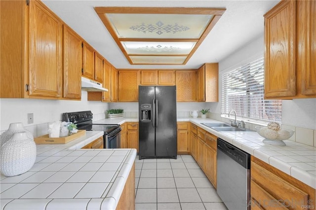 kitchen featuring stainless steel dishwasher, tile counters, black fridge with ice dispenser, and electric range