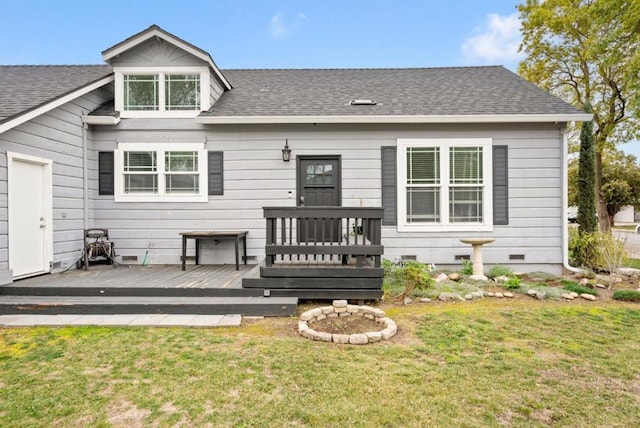 rear view of house featuring a wooden deck and a yard