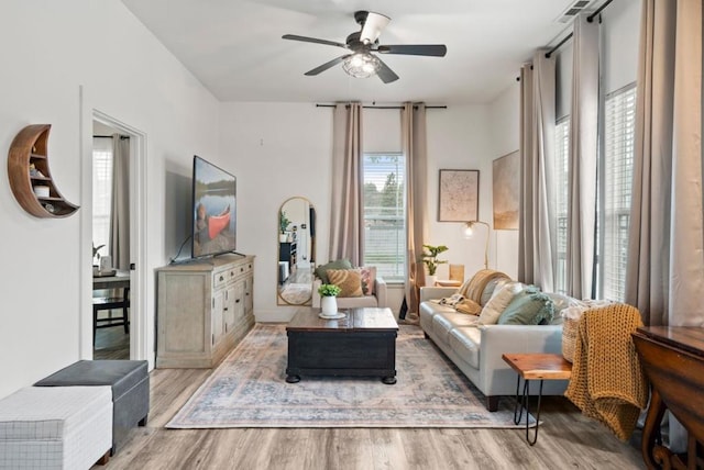 living room with light hardwood / wood-style flooring and ceiling fan