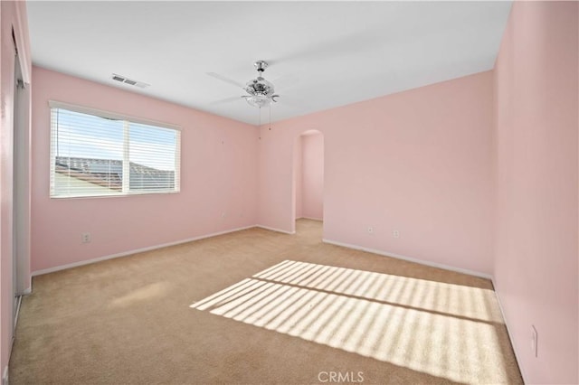 unfurnished room with light colored carpet and ceiling fan