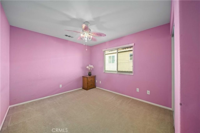 spare room featuring light colored carpet and ceiling fan