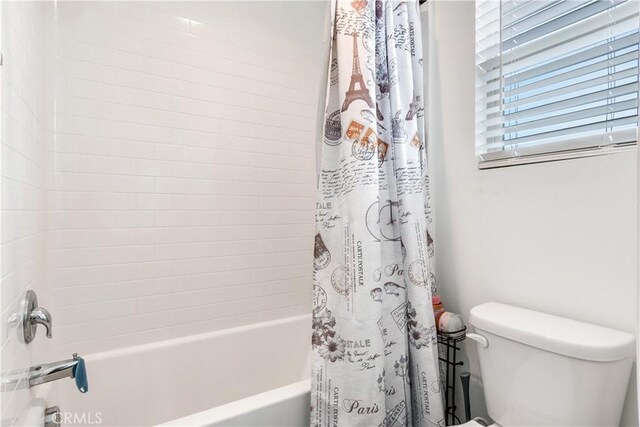 bathroom with toilet and shower / bathtub combination with curtain