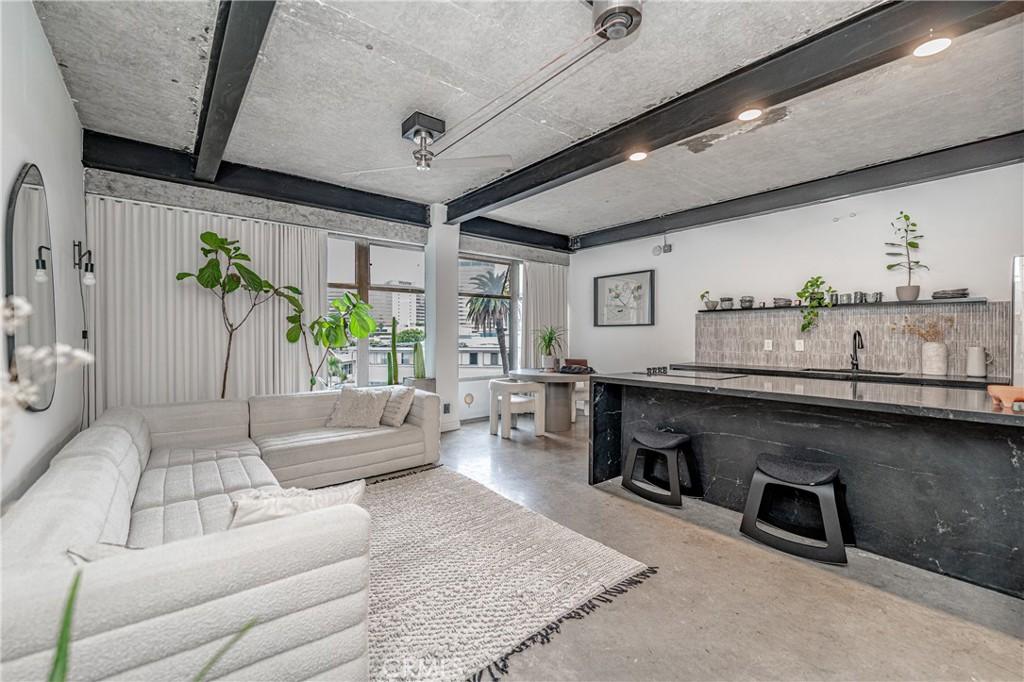 living room featuring sink and beam ceiling