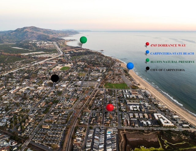 aerial view at dusk with a view of the beach and a water view