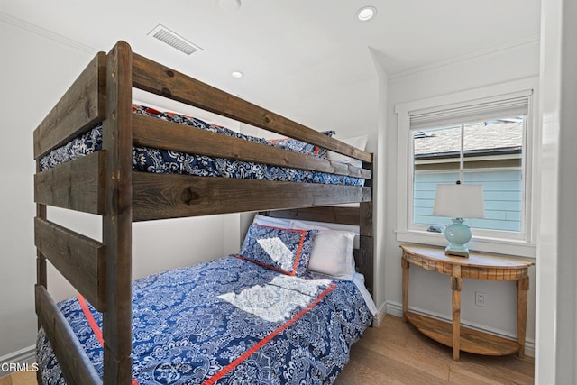 bedroom featuring crown molding and light wood-type flooring