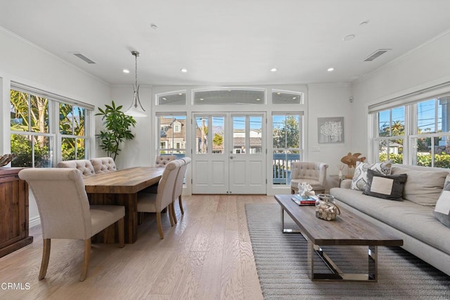 dining space with light hardwood / wood-style flooring and ornamental molding