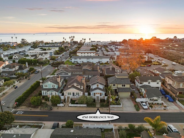 aerial view at dusk featuring a water view